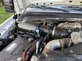 An engine compartment of a 2008 Ford F-450 showing various components including the air intake and battery with wiring and hoses visible