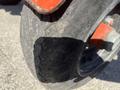A close-up of a tire from a Wallenstein WX540-0RA tow behind industrial log splitter showcasing the tread pattern and wheel design