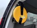 A yellow and black retractable measuring tape mounted on the interior side of a vehicle