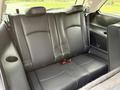A 2013 Dodge Journey with black leather seats in the rear passenger area featuring cup holders and seat belts in the center seat