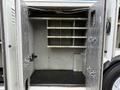 Open storage compartment of a 2011 International 4400 with several shelves and a small section at the bottom for additional storage