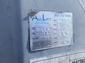 A 1997 Genie S-65 4X4 aerial lift with inspection information displayed on a weathered label attached to the equipment