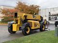 A yellow 2014 Caterpillar TL1055C telescopic handler with large tires and a boom arm extended behind it