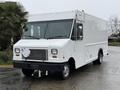 A 2012 Ford Econoline cargo truck with a white exterior and a boxy design featuring a prominent front grille and large windshield
