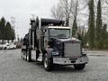 A 2018 Kenworth T800 truck with a black tank and a silver front grille parked on gravel
