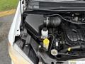 A 2017 Dodge Grand Caravan engine compartment showing the air filter housing and coolant reservoir along with various hoses and components