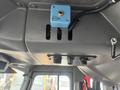 A blue control panel with knobs and slots mounted on a textured gray surface in a vehicle interior