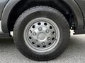 A close-up view of a silver wheel of a 2022 Ford Transit featuring a Goodyear Wrangler tire with a rugged tread pattern