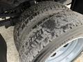 Close-up of a rugged tire from a 2013 Ford F-550 showcasing its deep tread pattern designed for heavy-duty performance