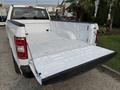 A white 2018 Ford F-150 truck with an open bed showcasing a clean interior designed for hauling cargo