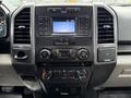 Dashboard of a 2018 Ford F-150 featuring a central control panel with buttons for radio media and climate controls and a digital clock display