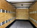 Interior of a 2018 Isuzu NPR box truck featuring wooden paneling and metallic strips along the walls
