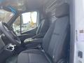 A 2025 Mercedes-Benz Sprinter interior featuring two black fabric front seats and a steering wheel with control buttons