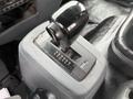 The gear shift of a 2007 GMC F7500 featuring a black lever with labels for various drive modes and a grey base