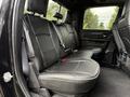 Black leather seats in the back of a 2024 RAM 2500 truck with ample space and seatbelt buckles visible