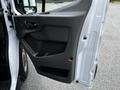 The open driver side door of a 2022 Ford Transit showing the interior door panel with a handle and storage compartment