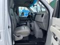 Interior view of a 2009 Ford Econoline showing the driver's seat and console with light gray leather upholstery and a simple dashboard design