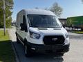 A white 2022 Ford Transit van with a black grille and front headlights parked on a street facing the viewer
