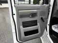 The interior door panel of a 2013 Ford Econoline featuring a gray design with a handle and a speaker grille