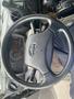Steering wheel of a 2012 Hino XJC720 with control buttons and a dashboard displaying gauges and indicators