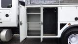 An open utility truck compartment with shelves and hooks inside