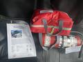 A 2017 Chevrolet Express with a red bag and a fire extinguisher placed on the front passenger seat next to a informational sheet about the vehicle