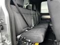 Interior view of the backseat of a 2014 Ford F-150 featuring black fabric seats with seatbelts