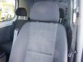 Front seat of a 2016 Mercedes-Benz Sprinter with a gray fabric cover and headrest visible in the foreground