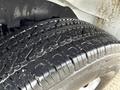 Close-up of a 2014 GMC Savana tire showing deep tread patterns and slight moisture on the rubber surface