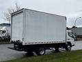 A 2021 Mitsubishi FE box truck viewed from the rear with a plain white cargo area and a black step at the back