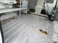Interior of a 2008 Ford Econoline with a clean white metal floor and storage compartments along the sides