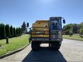 A yellow and gray 2022 TerraMac Tracked Dump with tracks and a cab viewed from the front