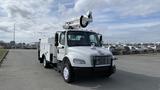 White 2010 Freightliner M2 106 with a bucket lift on top and utility compartments on the side parked on a paved lot