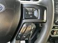 Close-up of the steering wheel controls of a 2018 Ford F-550 featuring volume and phone buttons