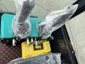 2024 AGT Industrial Green QH13R Mini Excavator control levers and a yellow toolbox with a label marked Tools Box on a black surface
