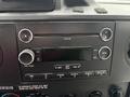 Dashboard controls of a 2014 Ford E-350 featuring a radio with CD and auxiliary inputs and various knobs for volume and tuning