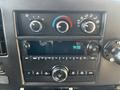 Close-up of the dashboard controls of a 2019 Chevrolet Express featuring dials for temperature and air flow along with a radio display showing the time 938