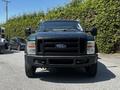 A black 2008 Ford F-550 Super Duty truck facing forward with large side mirrors and amber lights on the roof