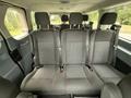 The interior of a 2017 Ford Transit T150 XLT showing multiple rows of black fabric seats with seat belts
