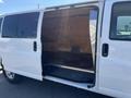 A 2012 Chevrolet Express van with an open side door revealing an empty cargo area