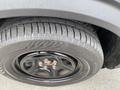 Close-up of a black tire mounted on a wheel showing tread pattern and silver lug nuts on a 2021 Ford Explorer