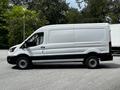 A white 2022 Ford Transit van with a high roof and no windows on the side, viewed from the passenger side