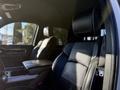A black leather seat in a 2023 RAM 3500 truck with a logo visible on the seat and an armrest beside it