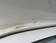 Close-up view of the edge of a 2020 Chevrolet Express showing wear and minor damage along the seam and trim area