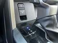 Close-up of the gear shift area in a 2023 Toyota Tundra featuring a push button for parking and a sleek digital shift console with P R N S D indicators