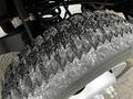 Close-up of a tire on a 2012 Ford F-550 showcasing rugged tread patterns with visible wear and dirt on the surface