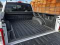 The image shows the bed of a 2021 Ford F-150 with a textured black lining and a Ford logo on the sidewall