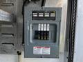 A gray electrical distribution panel with multiple circuit breakers and labels for each breaker