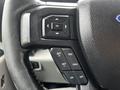 Steering wheel controls of a 2017 Ford F-150 featuring buttons for navigation and cruise control settings