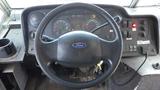 Steering wheel and dashboard of a 2011 Ford Econoline with gauges buttons and ignition keys visible